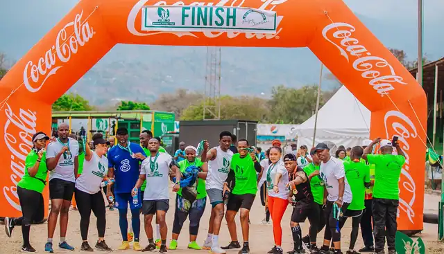 A group of runners celebrating under the finish arch