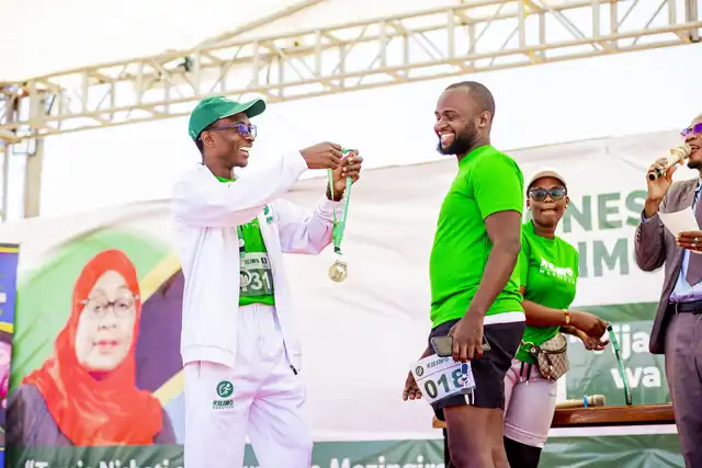 A finisher receiving a medal on stage