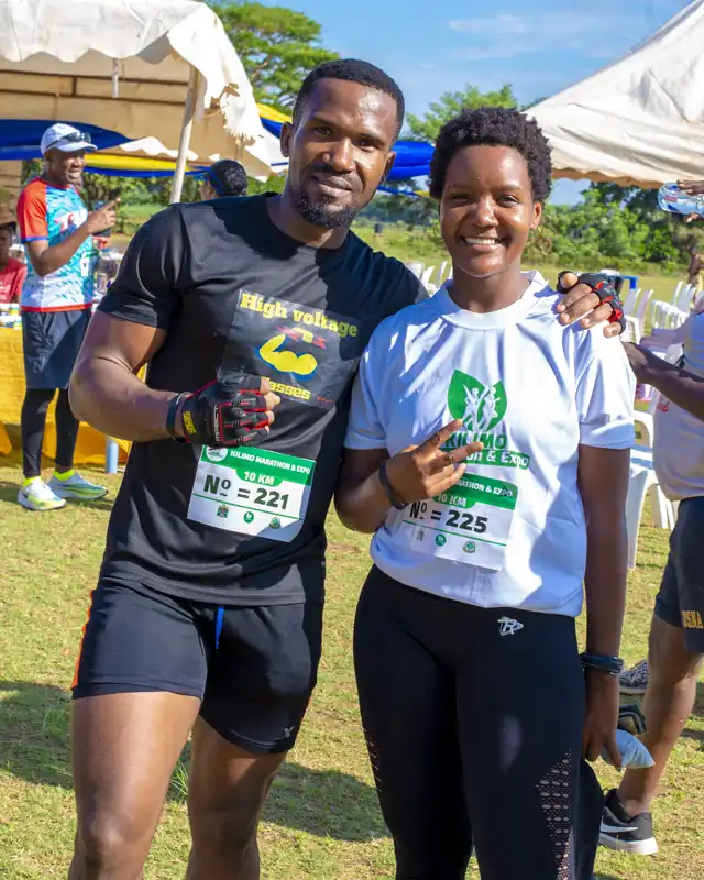 Two runners smiling with their race numbers after the run