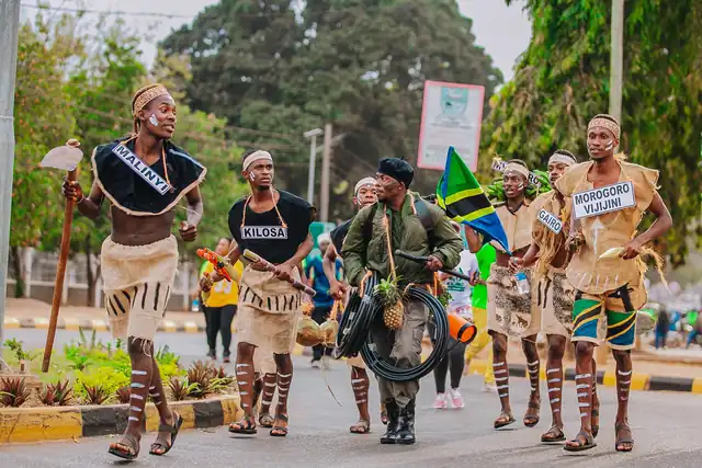 Traditional dancers from Morogoro's districts leading the way with a Tanzanian flag